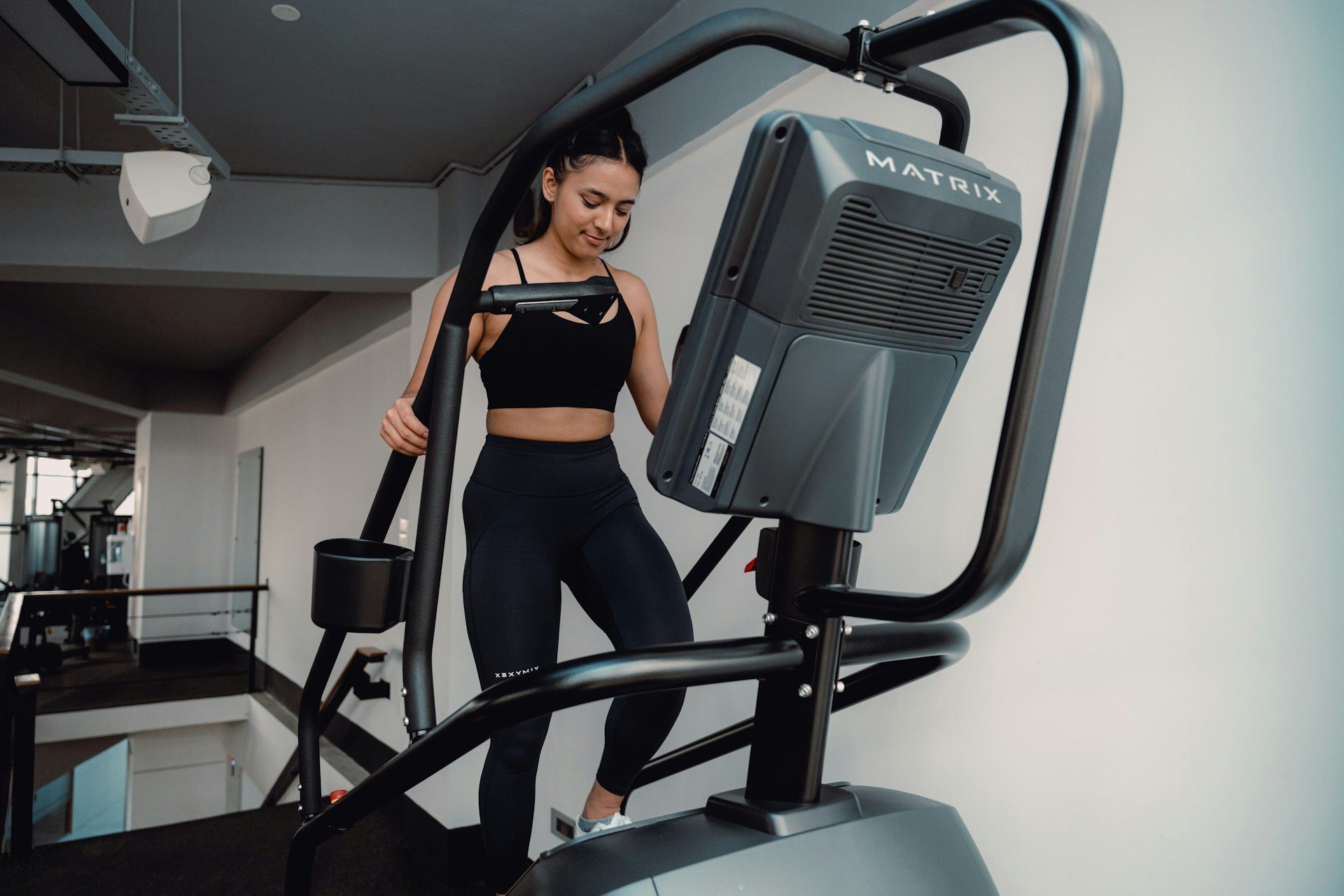 female working out on a elliptical machine at a gym